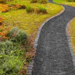 Rundle fines pathway bordered by brick edging and surrounded by natural landscaping, creating a durable, compacted walking surface that blends seamlessly into outdoor garden spaces.