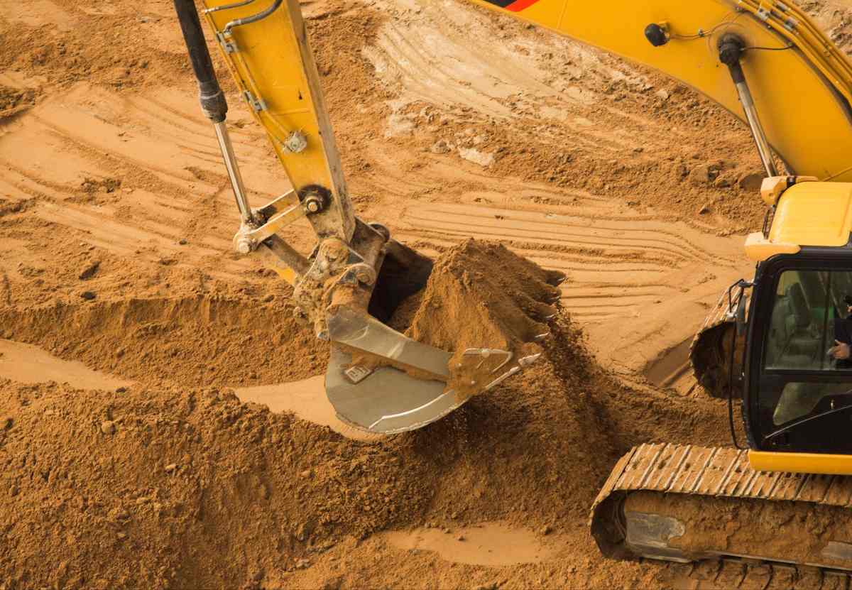 Excavator moving clay in construction during site preparation and earthwork.