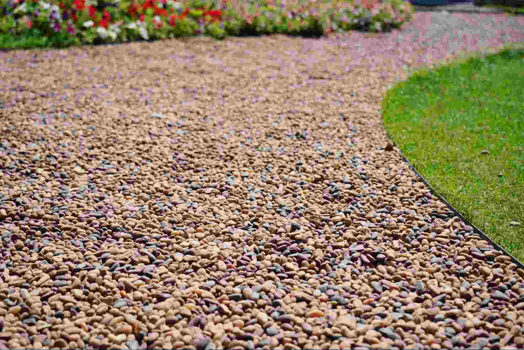 Tan rock landscaping material covering a pathway, showing decorative gravel used for outdoor landscaping and garden design.