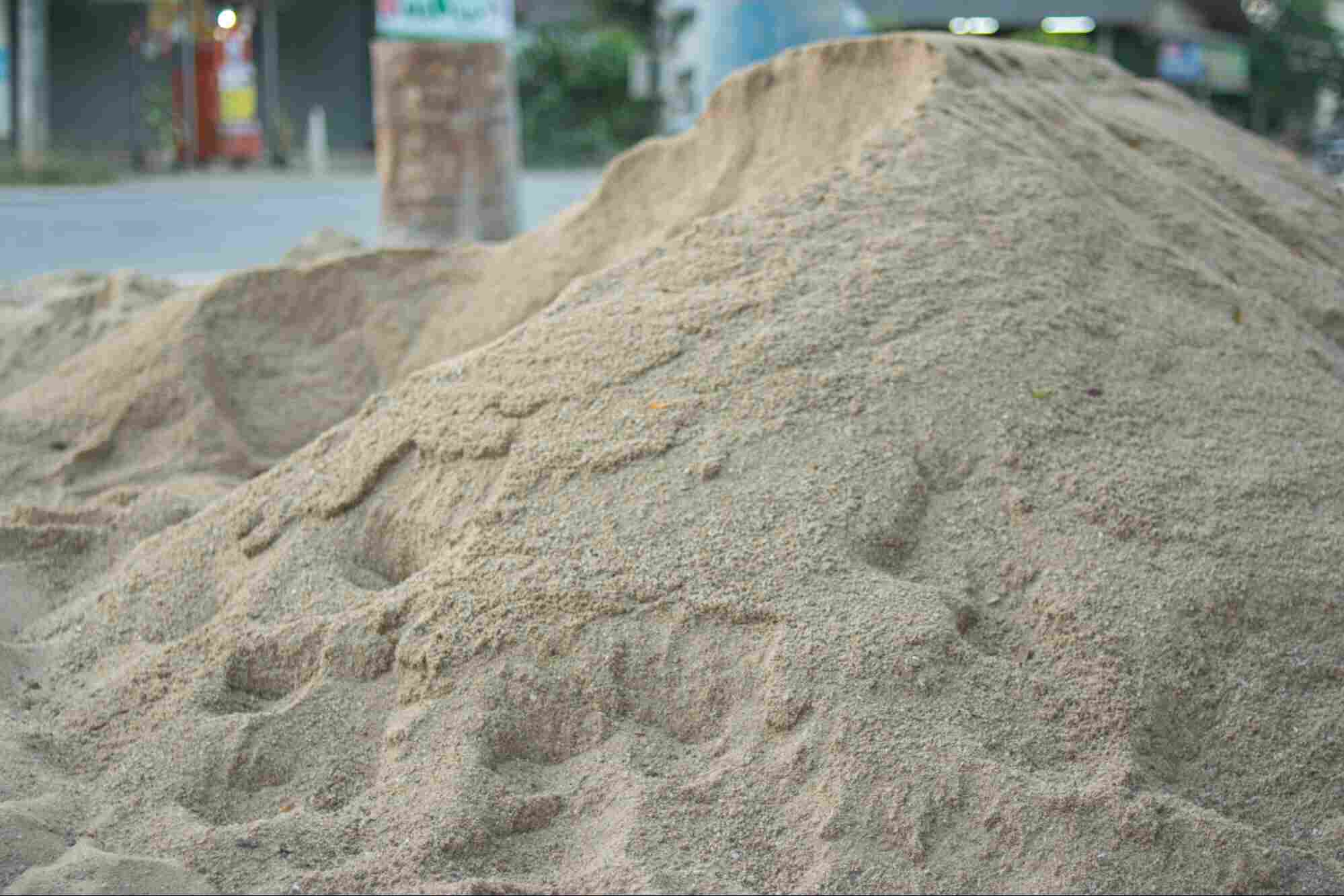 Washed construction sand piled for building and landscaping projects, showing fine, clean sand material ready for use.